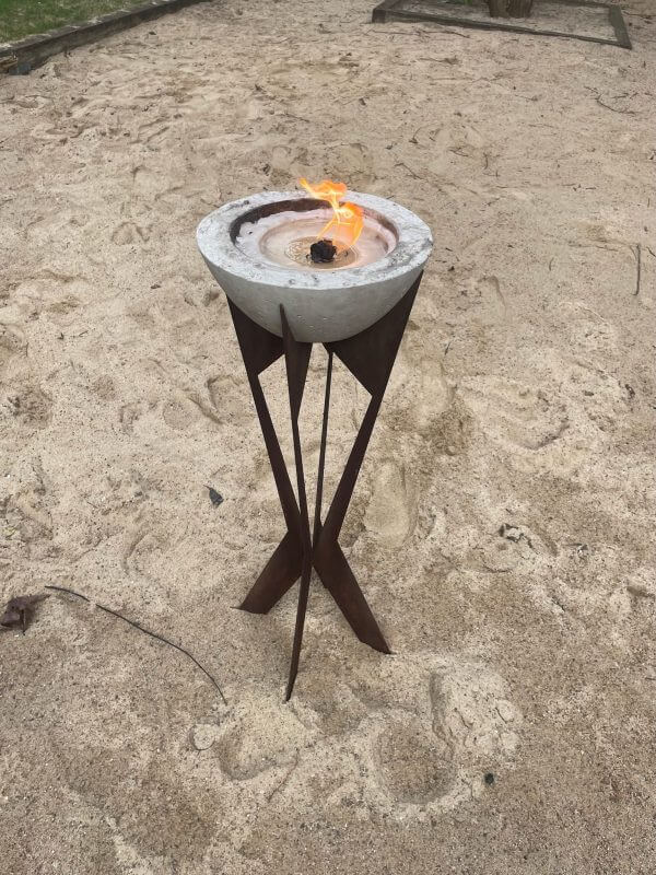 Eine Feuerstelle im Sand mit einem Feuer darin.